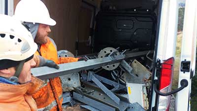 close up view of a pile of typical factory and industrial site scrap metal including machinery being loaded into a white van by two howarths clearance experts